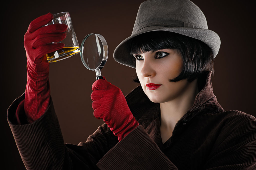 Female Detective with magnifying glass seeks answers.